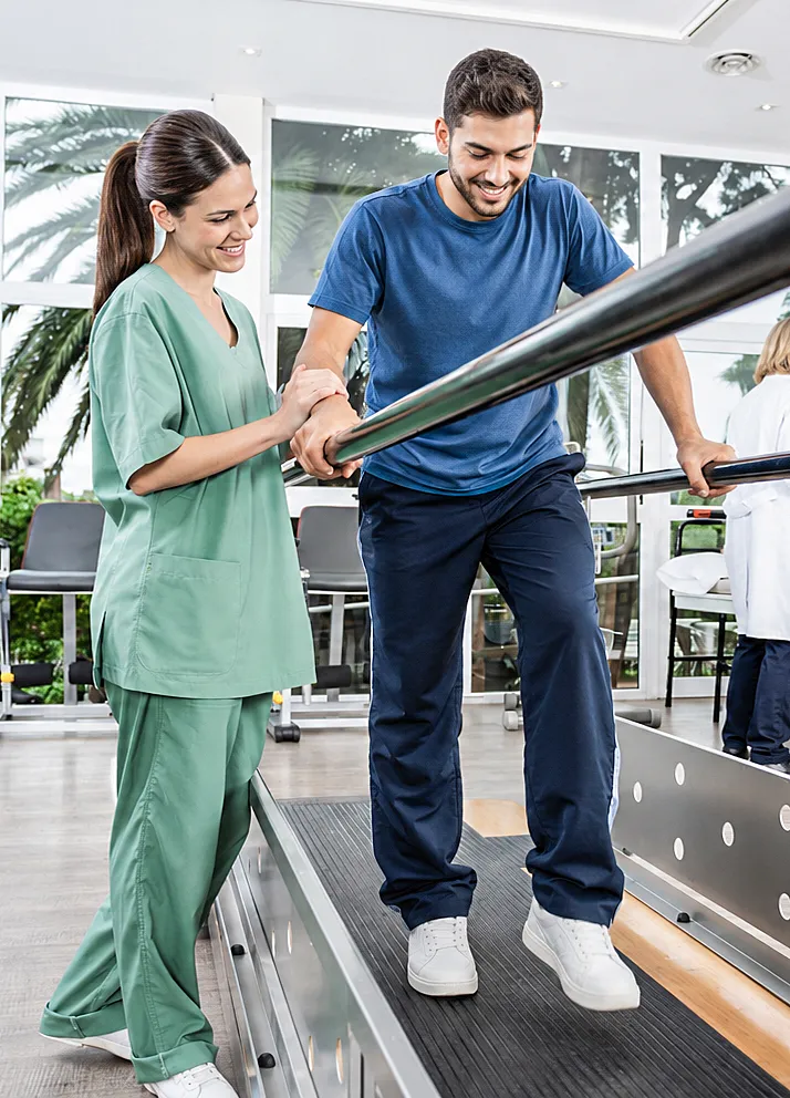 Neurologisch KI-generiertes Symboldbild: Junge Frau im grünen Kasack stützt jungen Mann auf dem Laufband